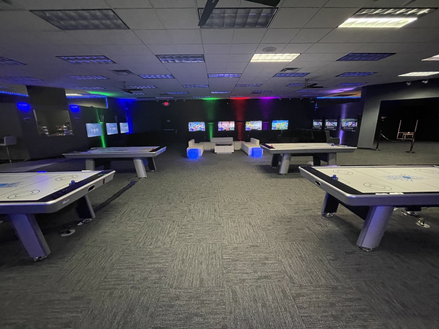 Gaming floor with arcade games and illuminated lounge seating